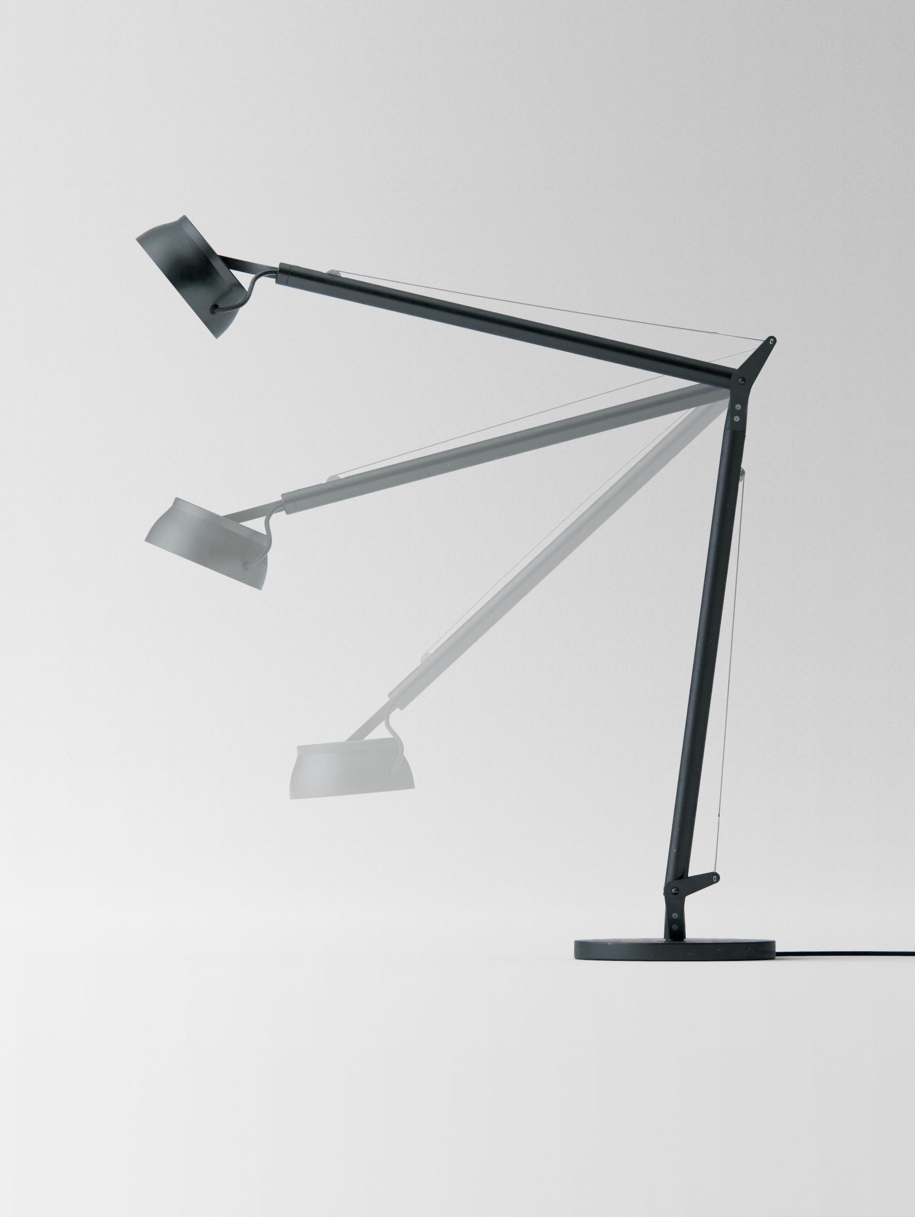 Multiple-exposure composite showing the lamp's arm moving through its full range of motion, against a light grey background.