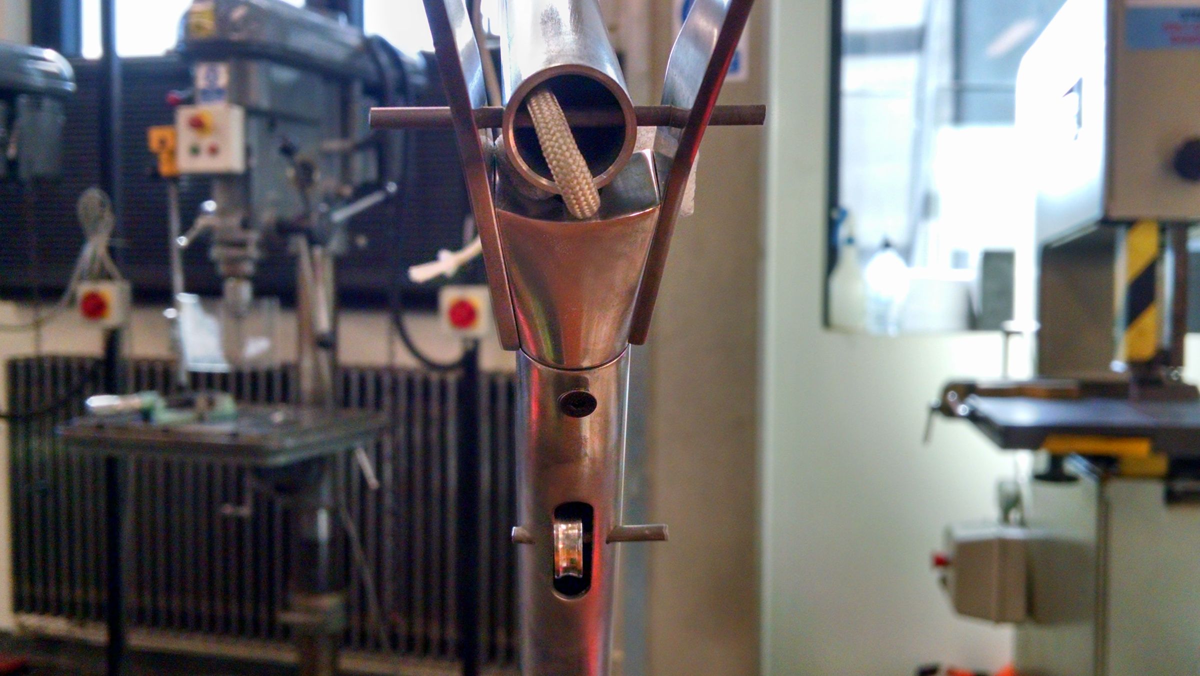 A person adjusting a workpiece clamped in a pillar drill press.