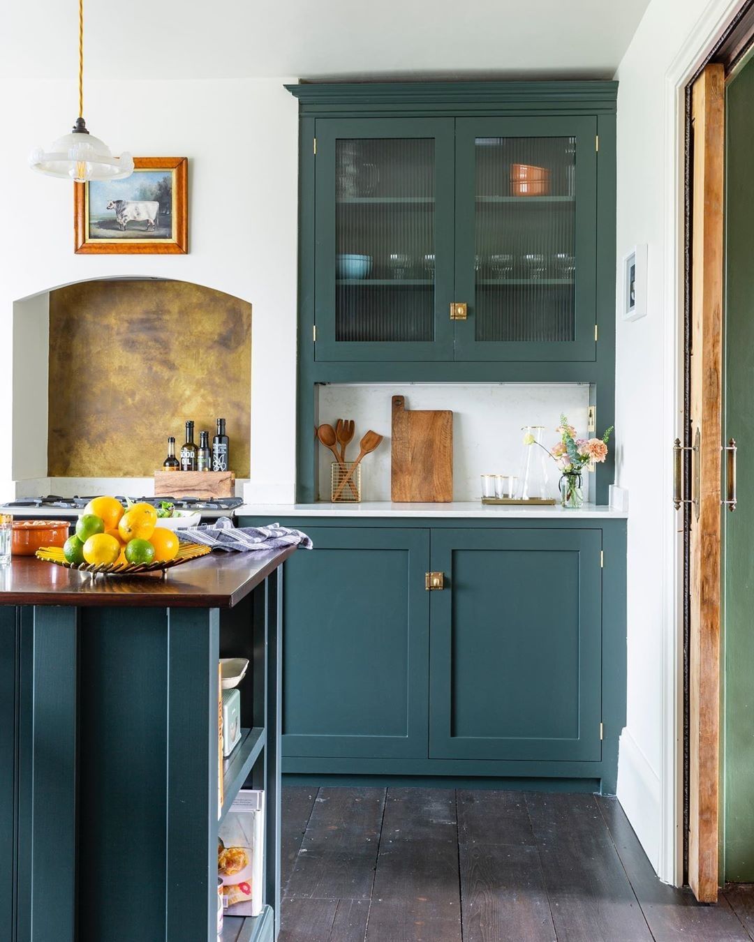 Close-up photo of one of the alcoves next to the cooker showcasing the reeded glass in the cabinet above as well as a tall marble splashback